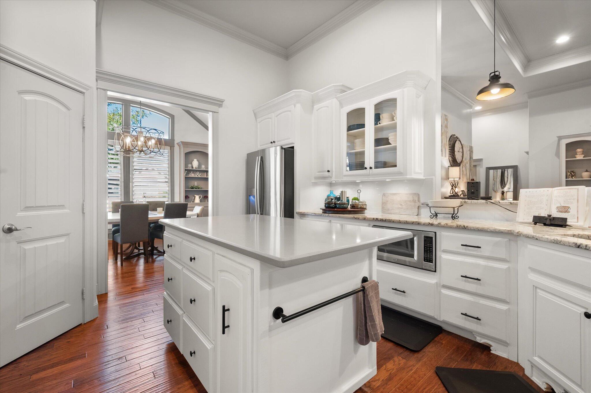 6021 89th Street Lubbock, TX 79424 - Photo 12 of 41 a kitchen with kitchen island white cabinets and stainless steel appliances