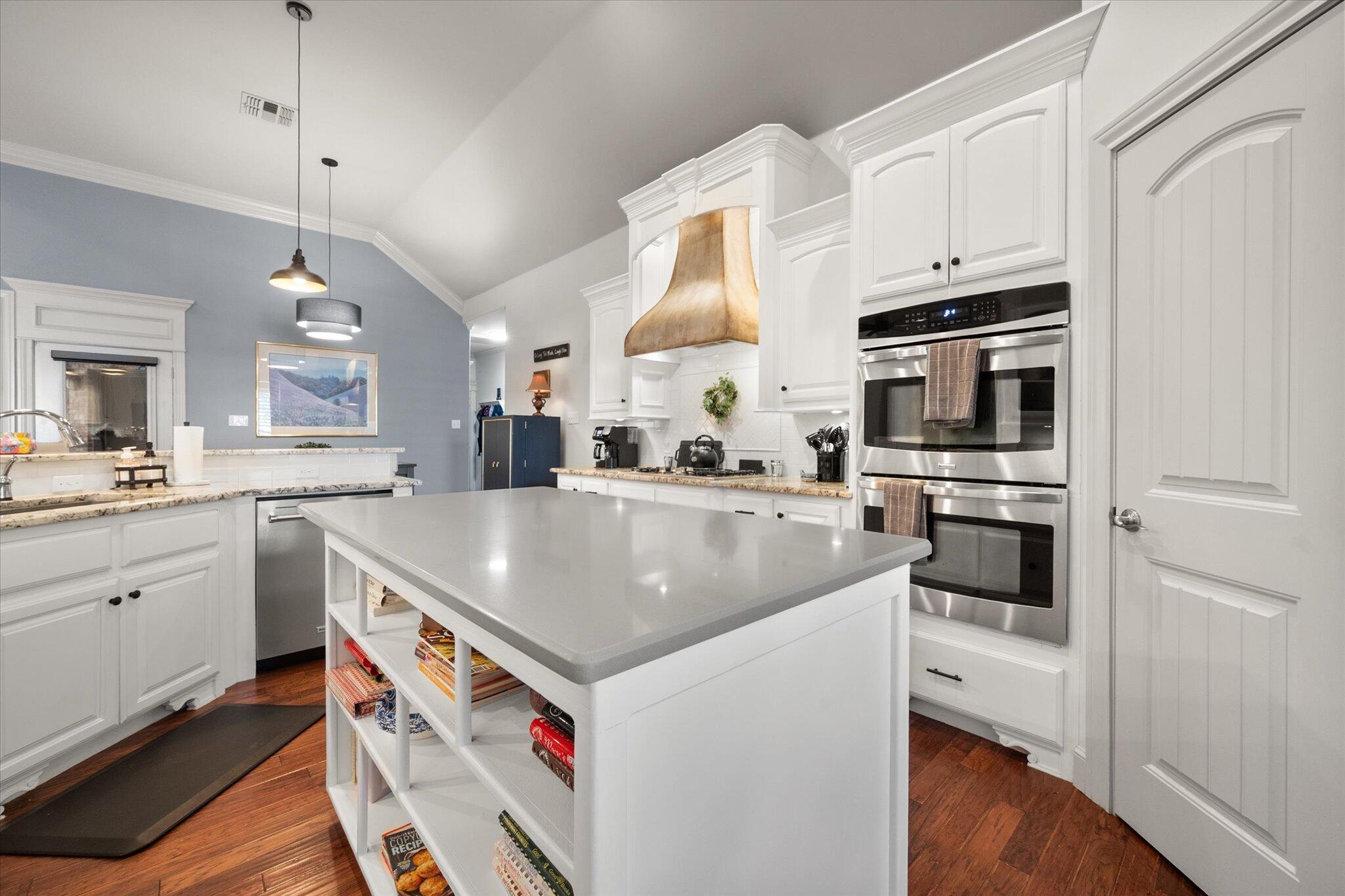 6021 89th Street Lubbock, TX 79424 - Photo 14 of 41 a kitchen that has a lot of cabinets in it and wooden floors