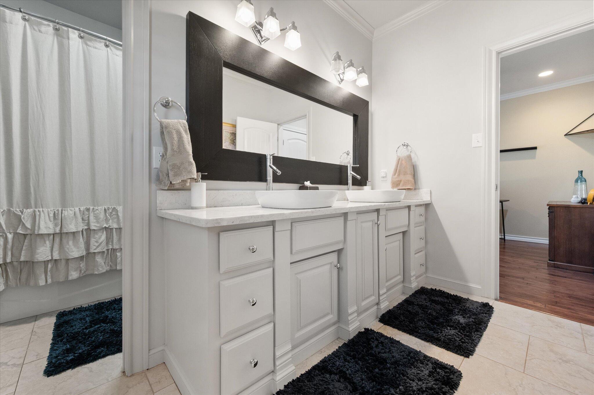6021 89th Street Lubbock, TX 79424 - Photo 25 of 41 a bathroom with a sink and a mirror