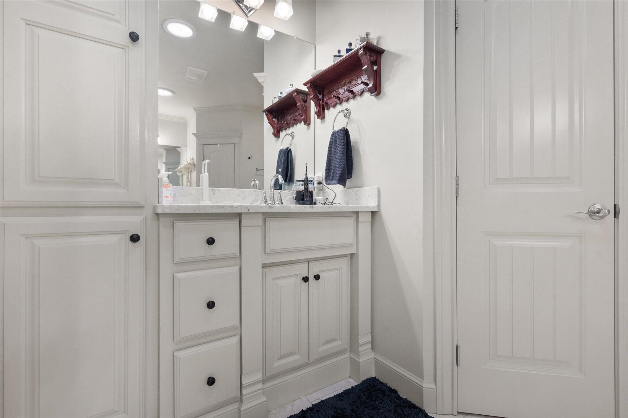 6021 89th Street Lubbock, TX 79424 - Photo 30 of 41 a bathroom with a sink vanity and mirror