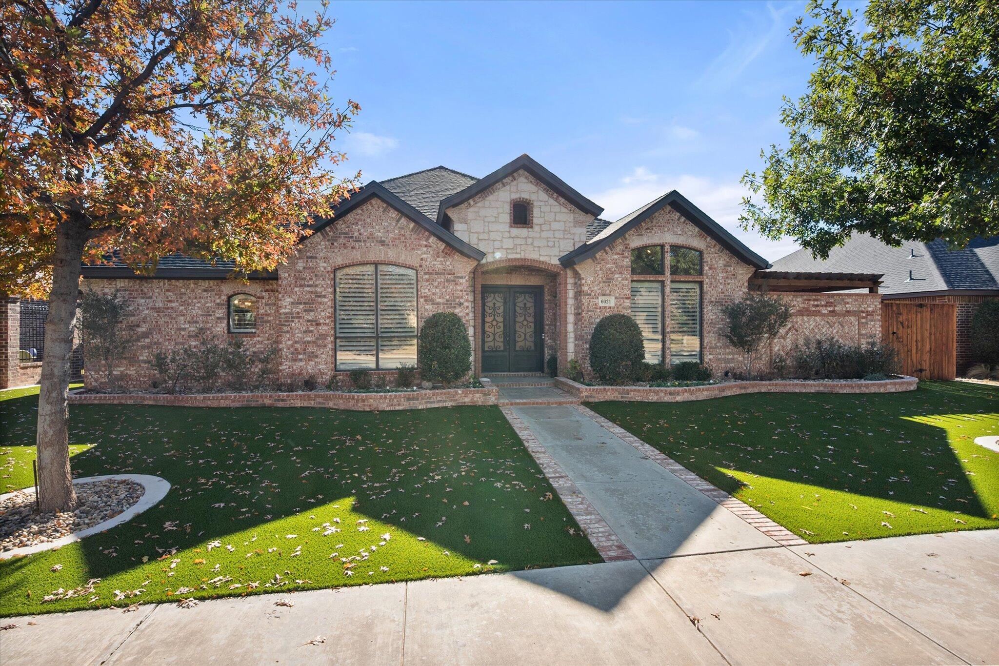 6021 89th Street Lubbock, TX 79424 - Photo 3 of 41 a front view of a house with a yard and garage