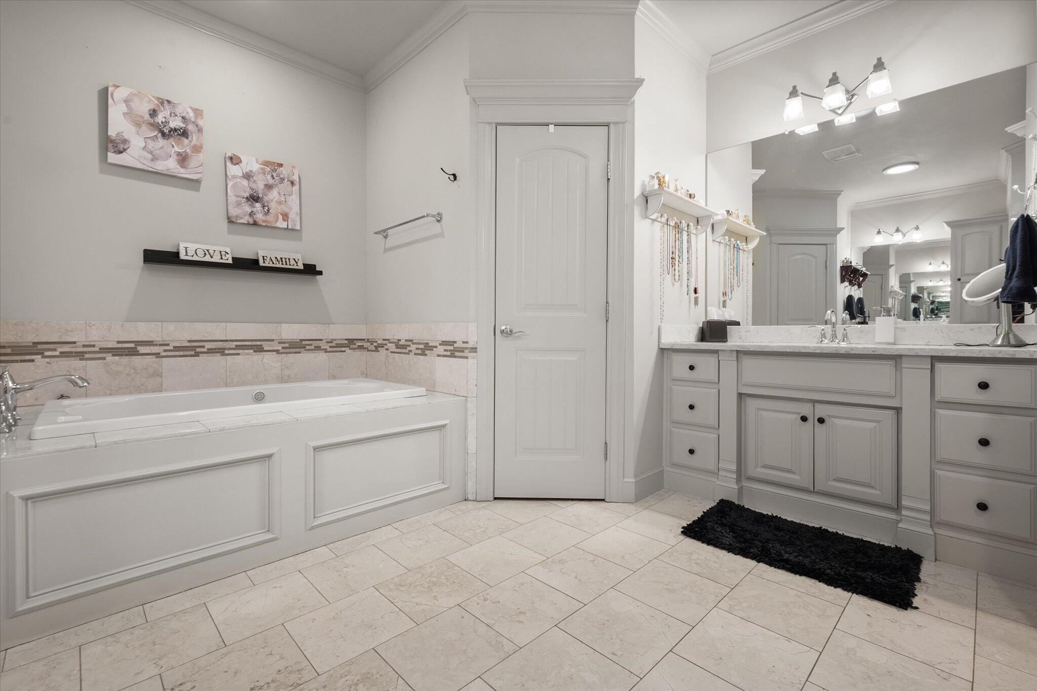 6021 89th Street Lubbock, TX 79424 - Photo 32 of 41 a spacious bathroom with a granite countertop sink a mirror and a