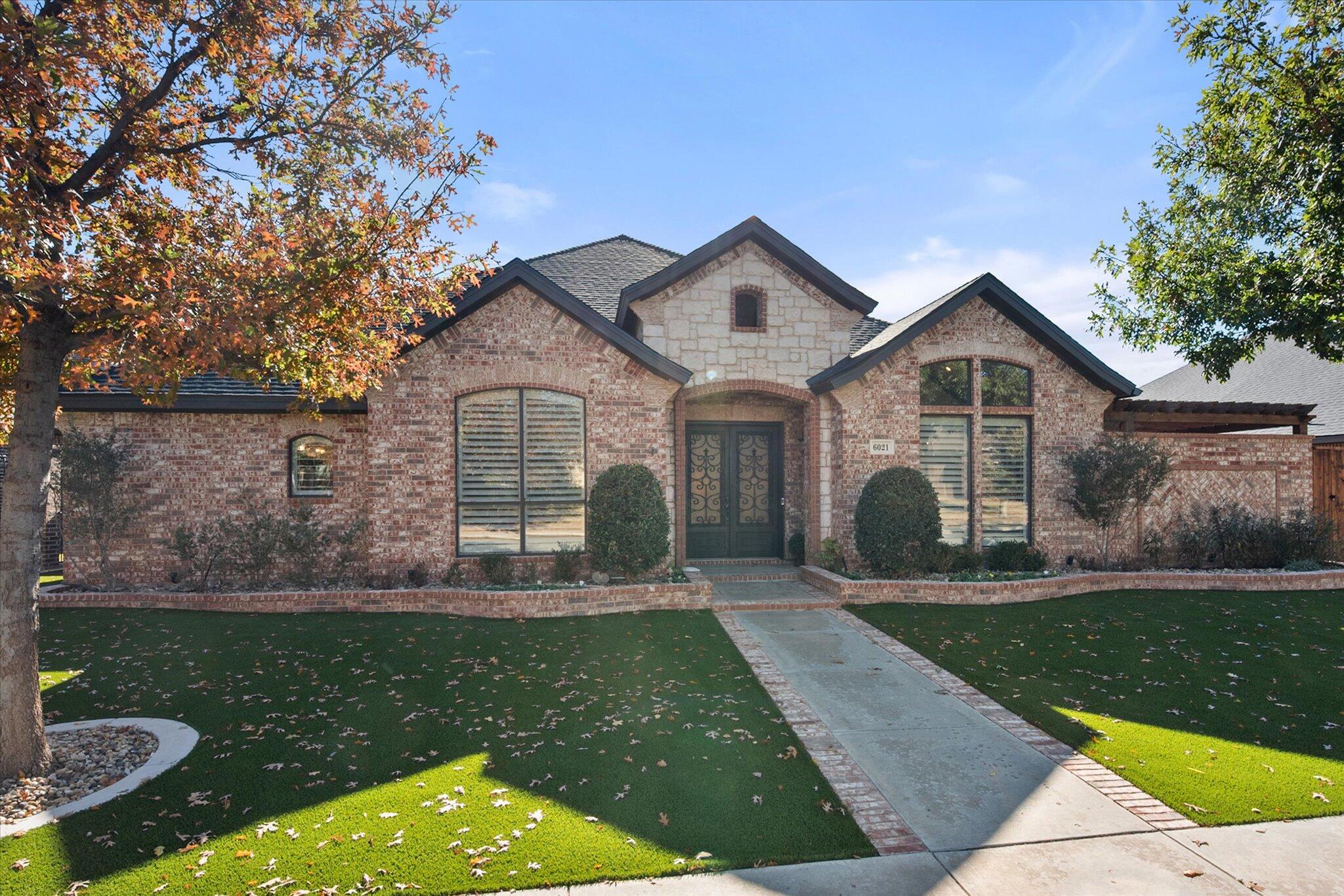 6021 89th Street Lubbock, TX 79424 - Photo 4 of 41 a front view of a house with a yard and garage