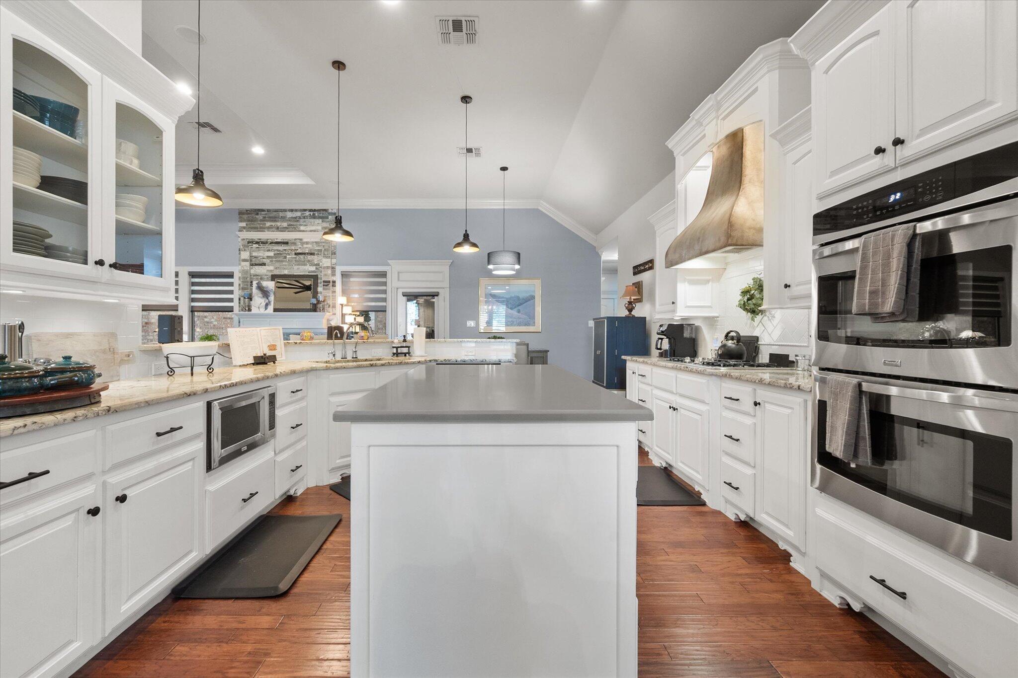 6021 89th Street Lubbock, TX 79424 - Photo 10 of 41 a kitchen with stainless steel appliances kitchen island granite countertop a stove a sink and white cabinets