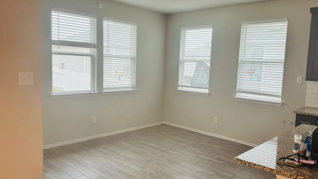 1305 Goforth Road Kyle, TX 78640 - Photo 11 of 23 Unfurnished dining area featuring light wood-type flooring and baseboards