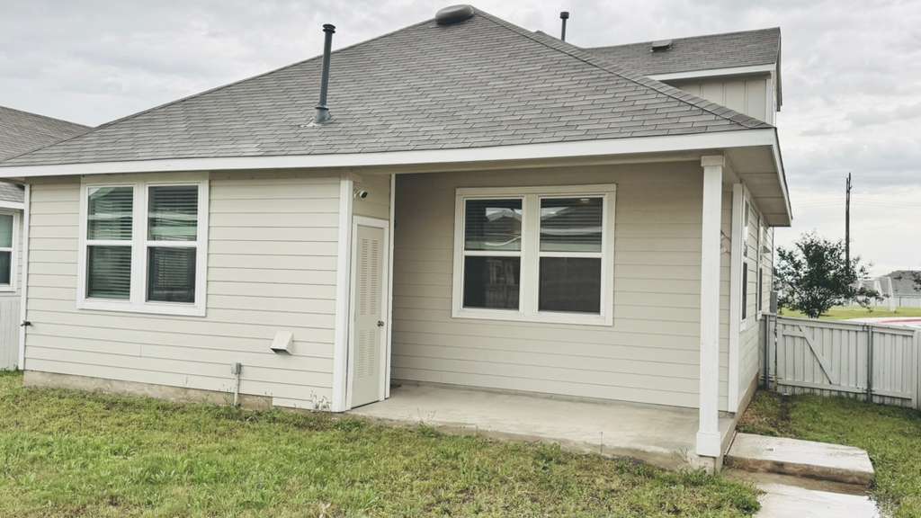 1305 Goforth Road Kyle, TX 78640 - Photo 21 of 23 Rear view of property featuring a shingled roof and a patio area