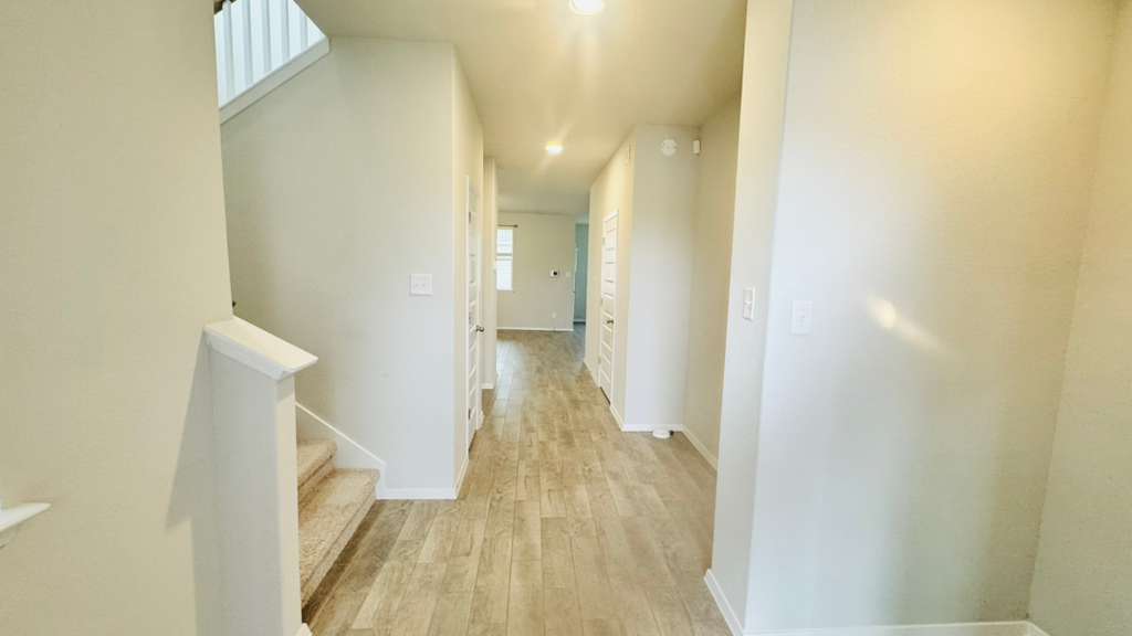 1305 Goforth Road Kyle, TX 78640 - Photo 6 of 23 Corridor featuring light wood finished floors and stairs