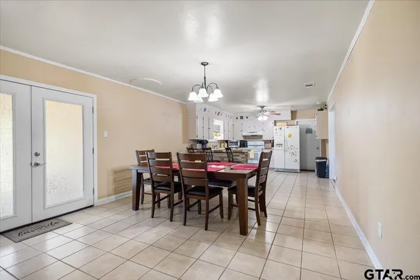 a bedroom with a bed and dresser with wooden floor