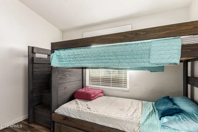 a bedroom with a bed and two windows