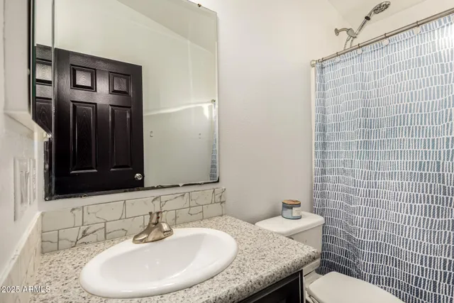 a bathroom with a sink a toilet and mirror