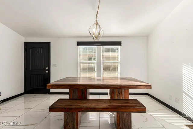 a view of dining room with chandelier and windows