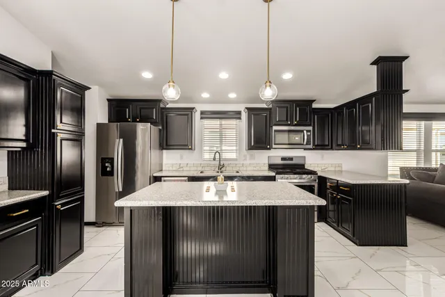 a kitchen with stainless steel appliances granite countertop a sink refrigerator and cabinets