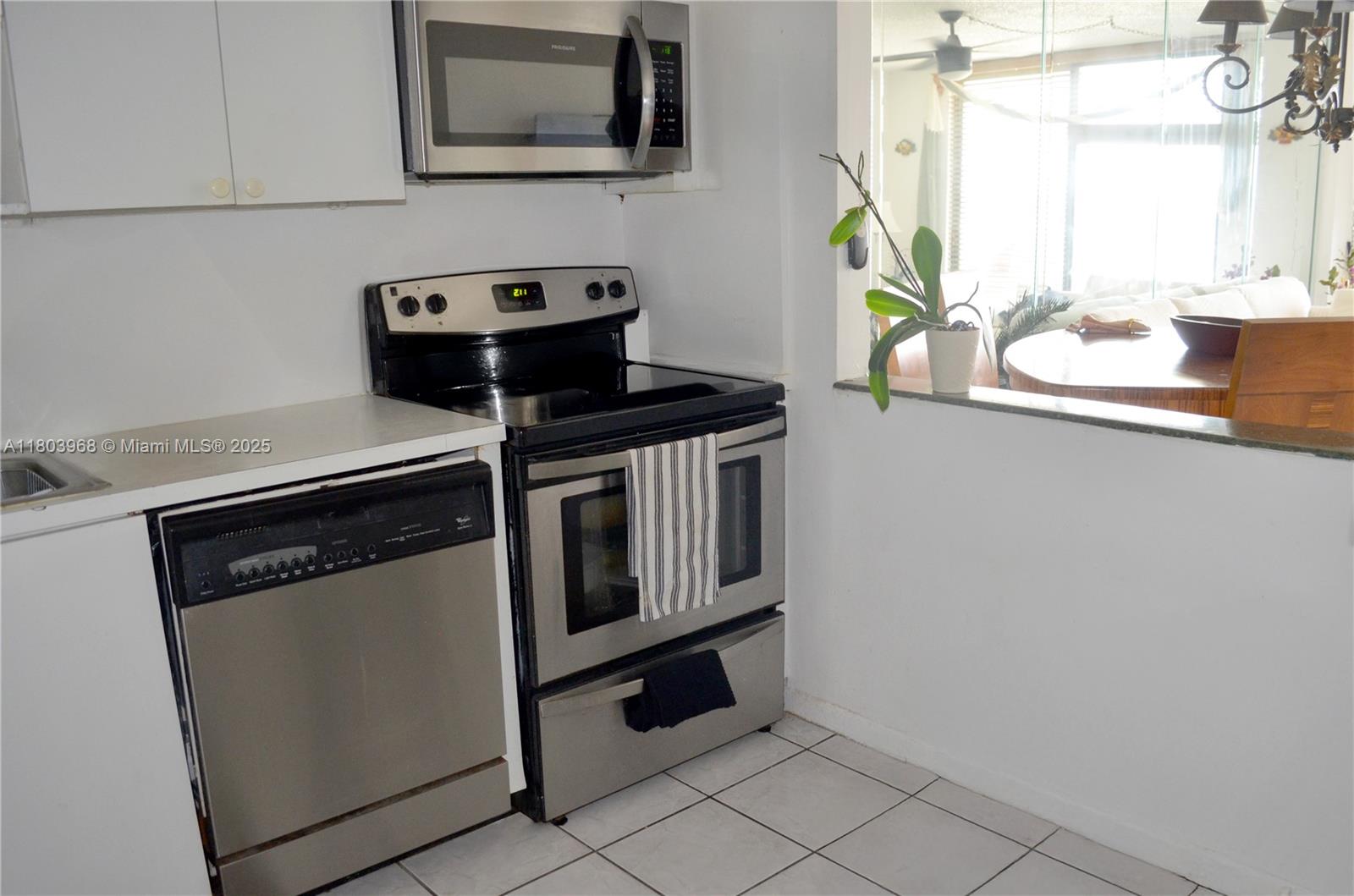 13499 Biscayne Boulevard, Unit 702 North Miami, FL 33181 - Photo 11 of 31 a kitchen with a stove and a microwave