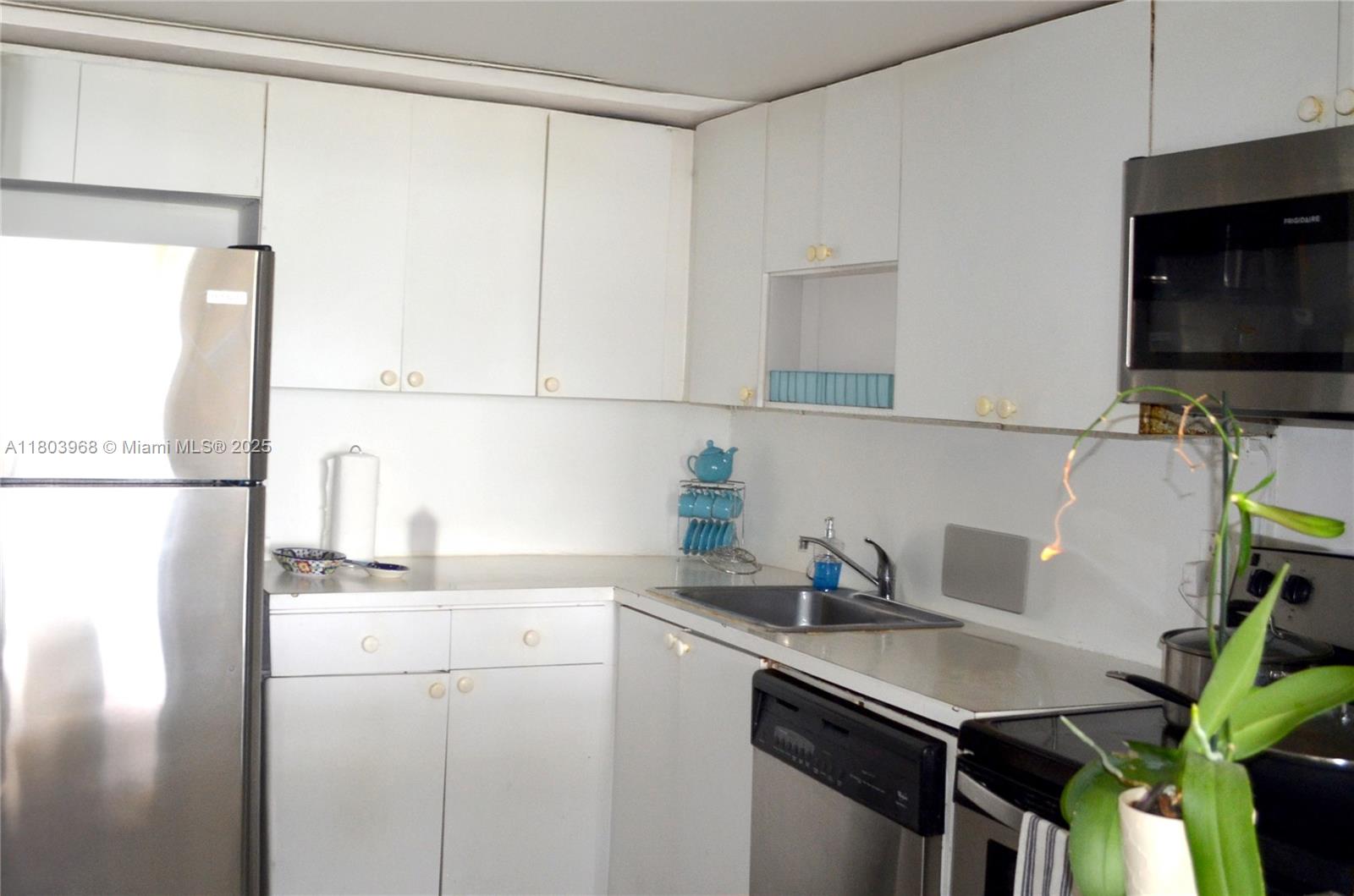 13499 Biscayne Boulevard, Unit 702 North Miami, FL 33181 - Photo 12 of 31 a kitchen with a sink cabinets and a refrigerator