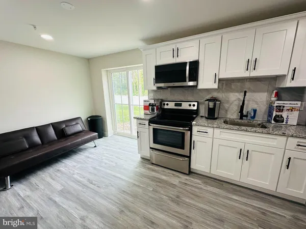a kitchen with granite countertop a stove a sink and a microwave