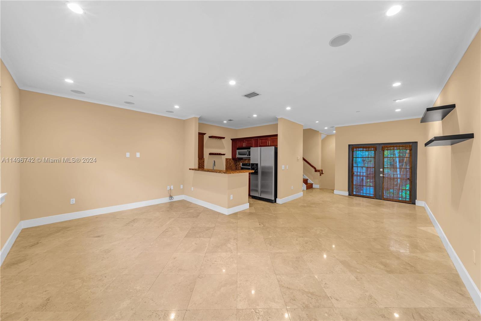 2829 Coconut Avenue, Unit 2829 Miami, FL 33133 - Photo 11 of 28 a view of an empty room with wooden floor and kitchen