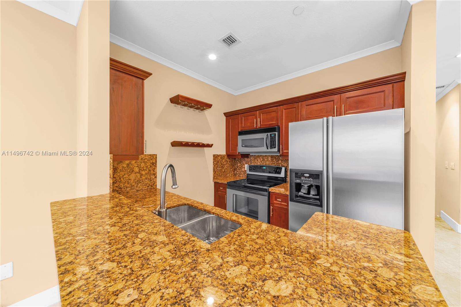2829 Coconut Avenue, Unit 2829 Miami, FL 33133 - Photo 9 of 28 a kitchen with kitchen island granite countertop a refrigerator stove microwave and sink
