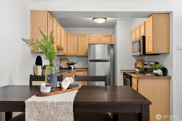 a kitchen with stainless steel appliances granite countertop a refrigerator sink stove microwave and cabinets