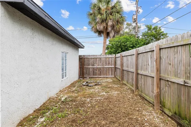 a backyard of a house with a barbeque and wooden fence