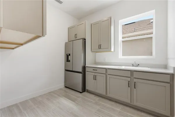 a kitchen with white cabinets and a refrigerator