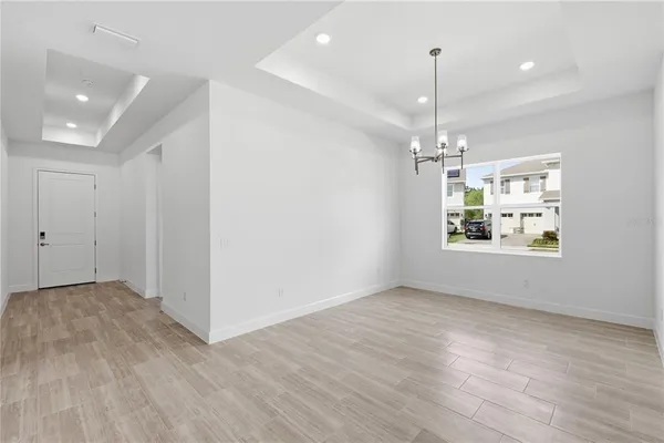 an empty room with wooden floor a ceiling fan and windows