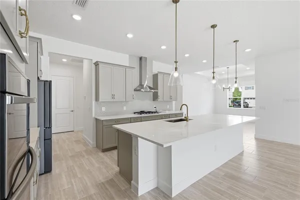 a kitchen with kitchen island a sink stove and refrigerator