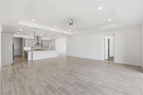 a view of kitchen with kitchen island stainless steel appliances cabinets and wooden floor