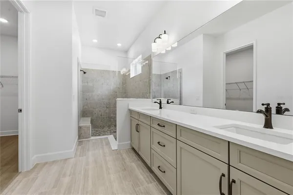 a spacious bathroom with a double vanity sink a mirror and a shower