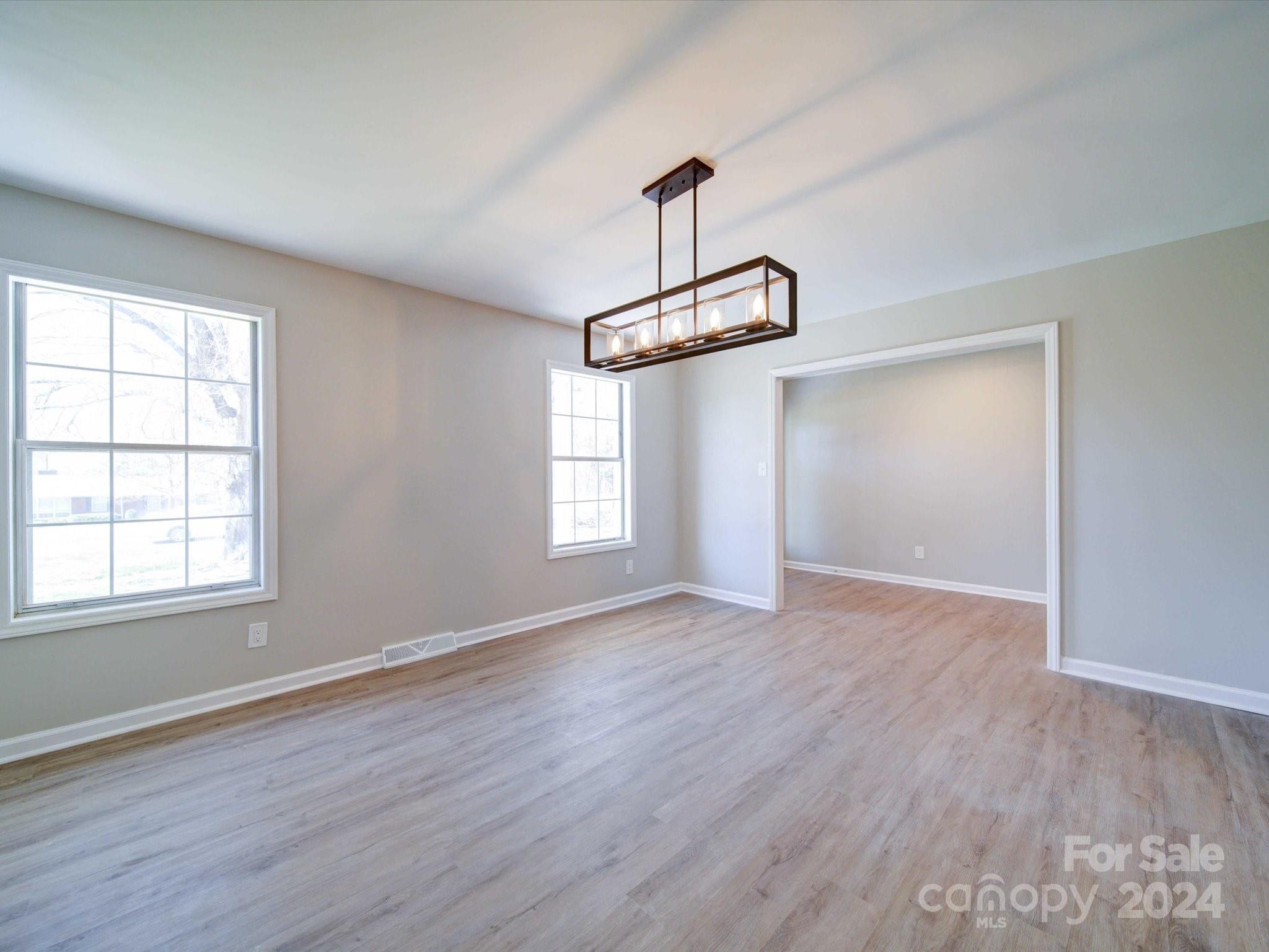 101 Hedgestone Drive Gastonia, NC 28056 - Photo 15 of 39 an empty room with wooden floor windows and cabinet