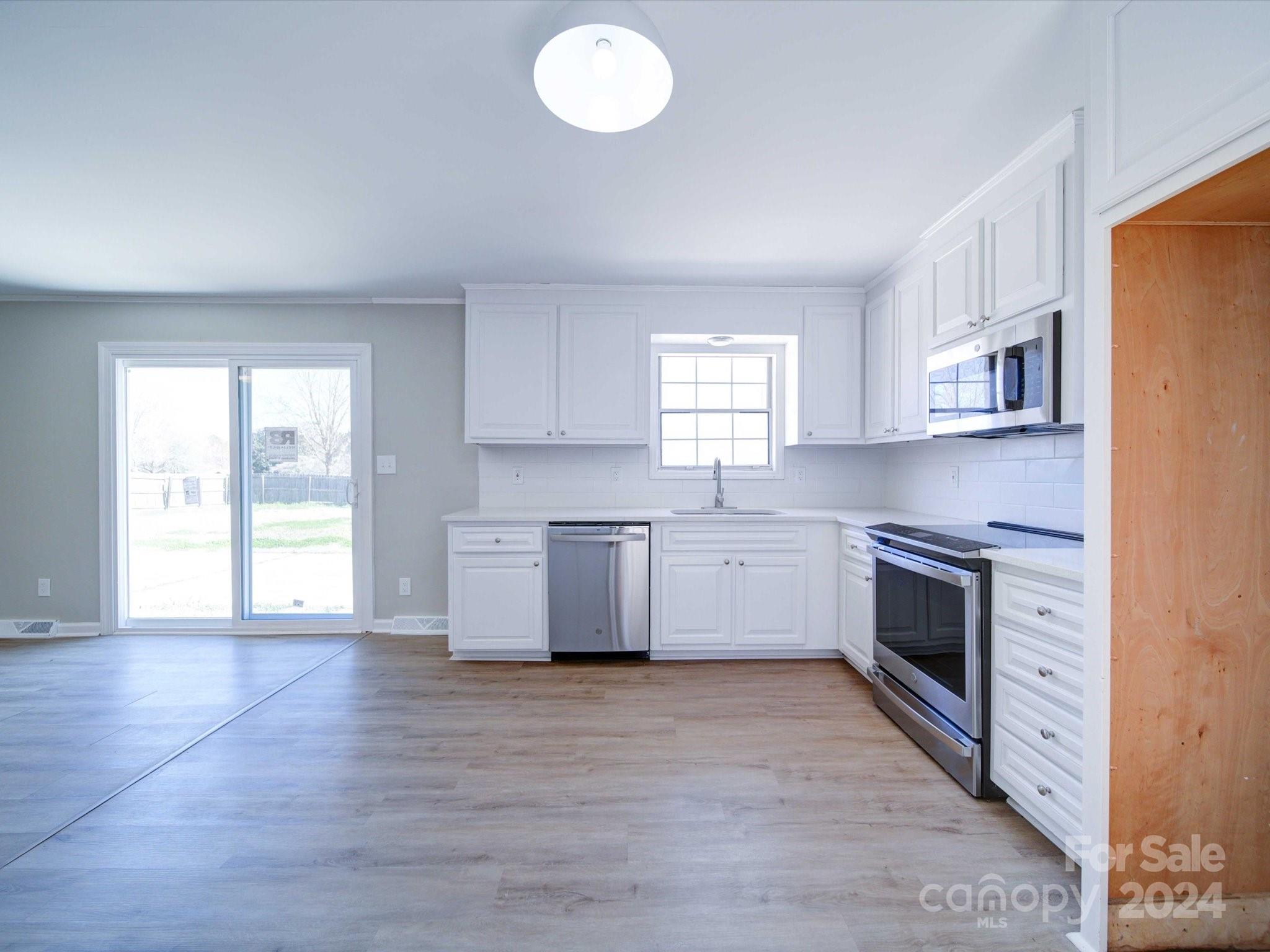 101 Hedgestone Drive Gastonia, NC 28056 - Photo 22 of 39 a large kitchen with stainless steel appliances granite countertop a stove a sink white cabinets and a window