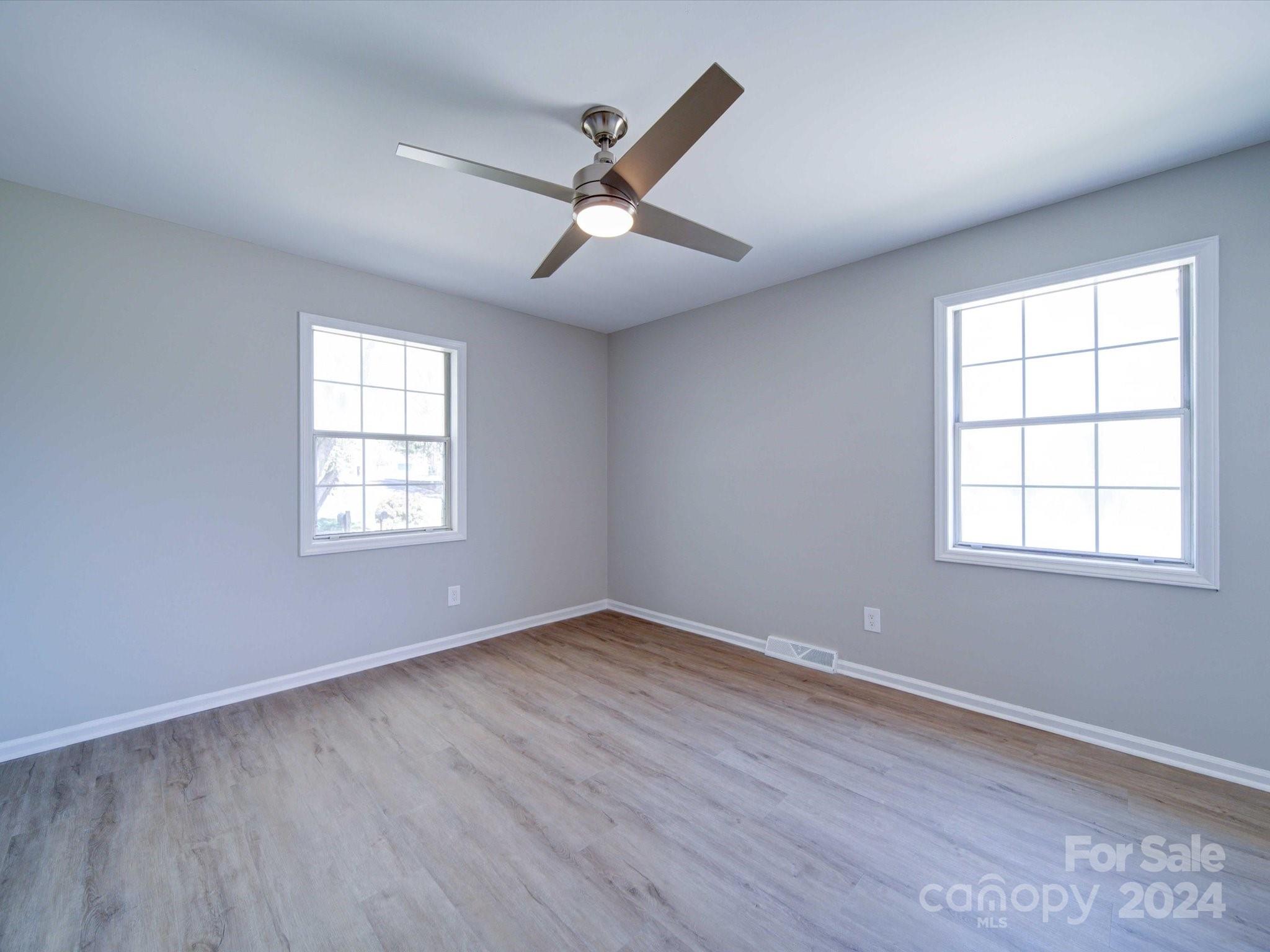 101 Hedgestone Drive Gastonia, NC 28056 - Photo 27 of 39 an empty room with wooden floor ceiling fan and windows