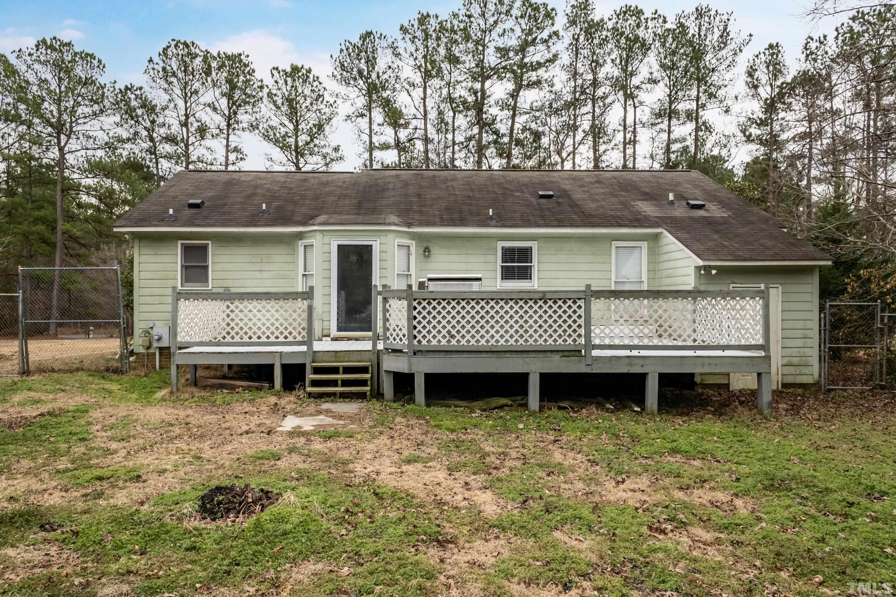9117 Ferrell Road Zebulon, NC 27597 - Photo 19 of 26 a front view of a house with a garden and deck