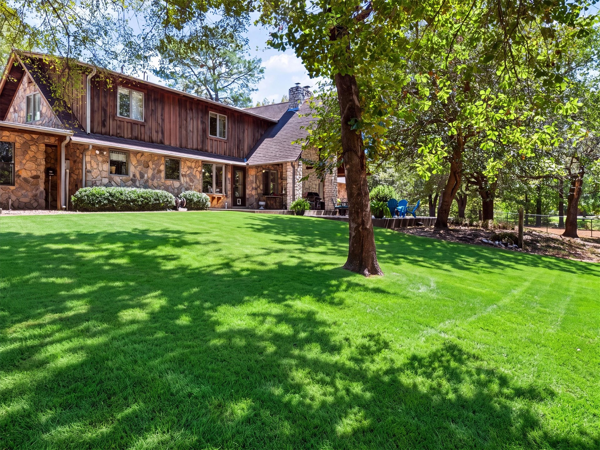 1133 West Chicken Fight Road Atoka, OK 74525 - Photo 6 of 49 Expansive green lawn with mature trees and stone and wood-sided exterior