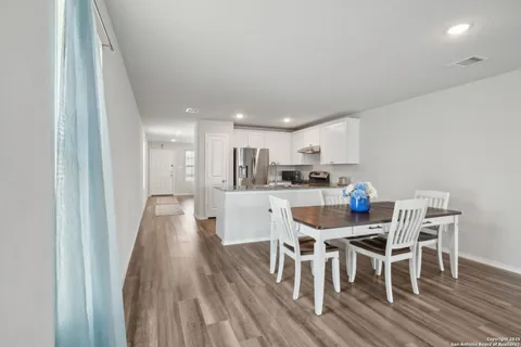 a dining room with furniture and wooden floor