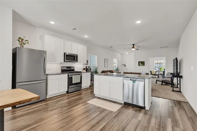 a kitchen with sink a refrigerator and white cabinets