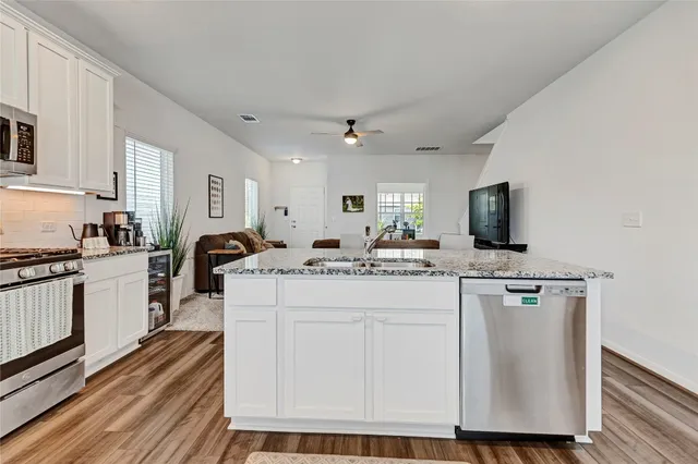 a kitchen with stainless steel appliances granite countertop a stove a sink and a refrigerator