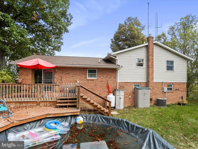 a view of a house with a yard and large trees