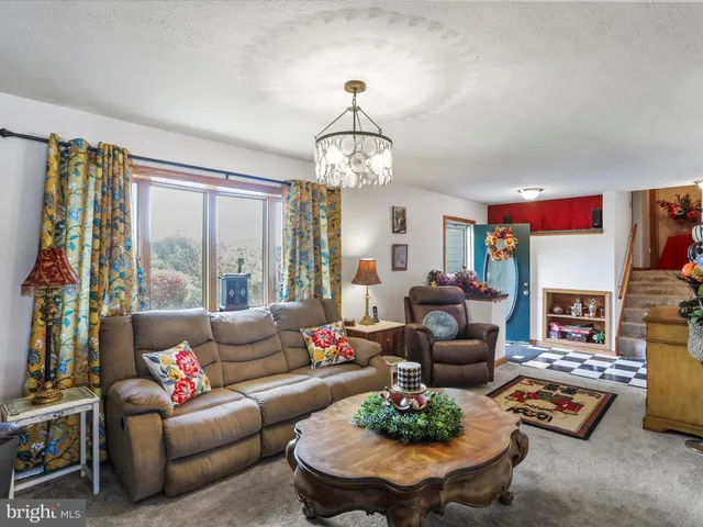 a living room with furniture chandelier and a large window