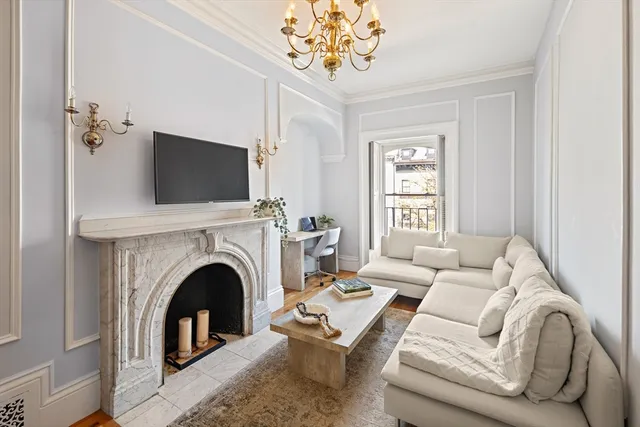 a living room with furniture a fireplace and a flat screen tv