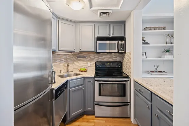 a kitchen with stainless steel appliances granite countertop a stove and a refrigerator