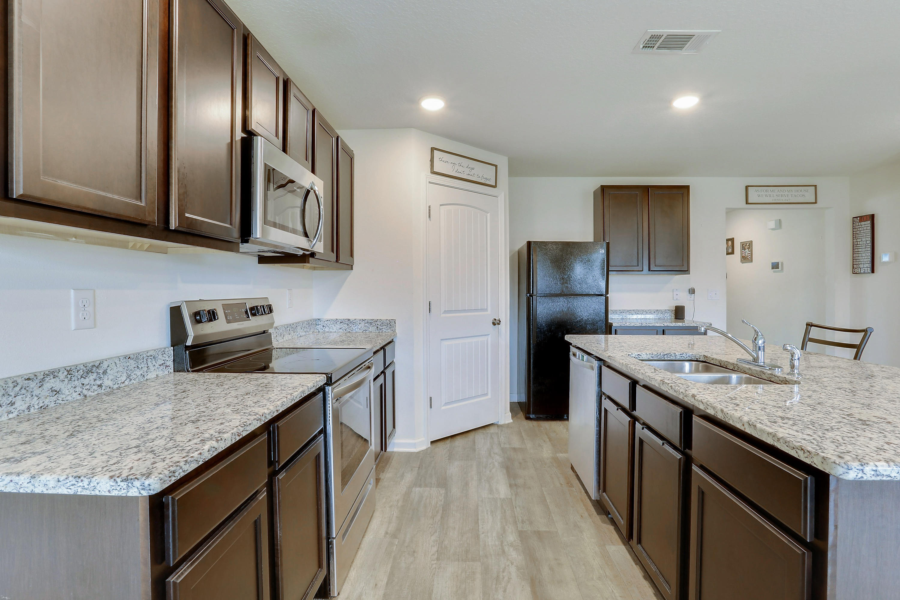 931 Merganser Way Crestview, FL 32539 - Photo 11 of 39 a kitchen with stainless steel appliances granite countertop a sink stove refrigerator and cabinets
