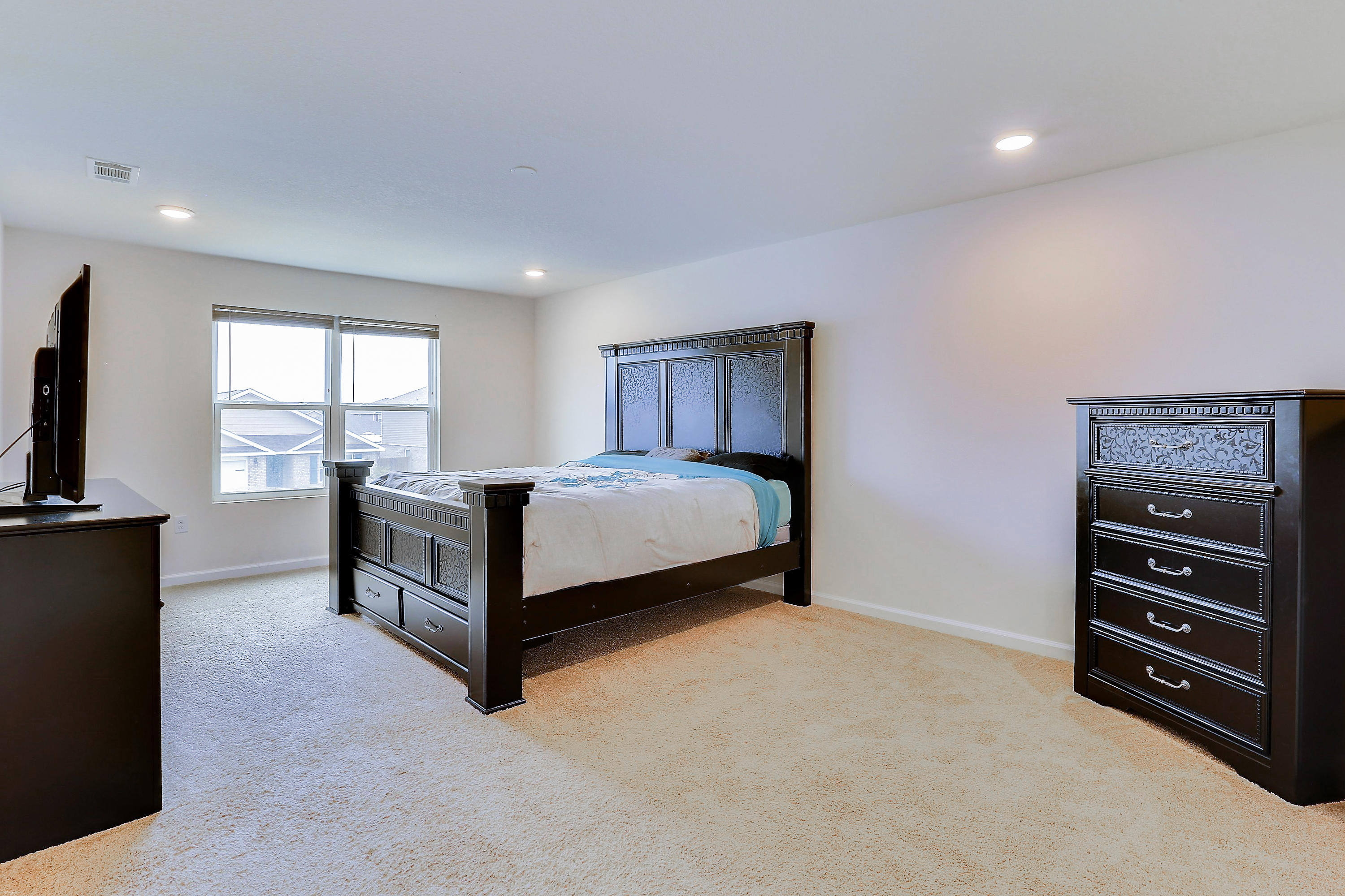 931 Merganser Way Crestview, FL 32539 - Photo 25 of 39 a spacious bedroom with a bed and a view of kitchen
