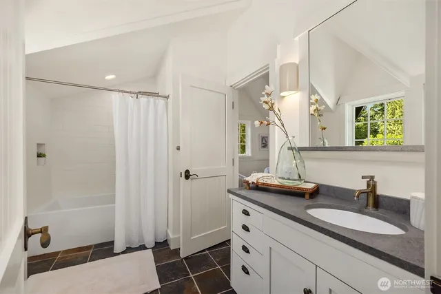 a bathroom with a sink a toilet a mirror and shower