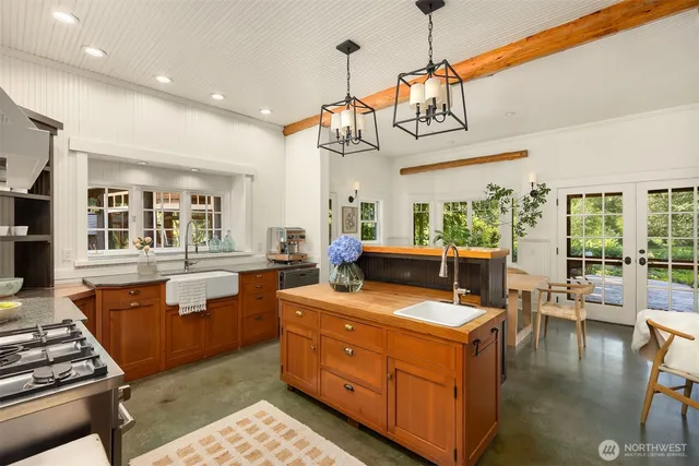 a kitchen with stainless steel appliances granite countertop a stove and a view of living room