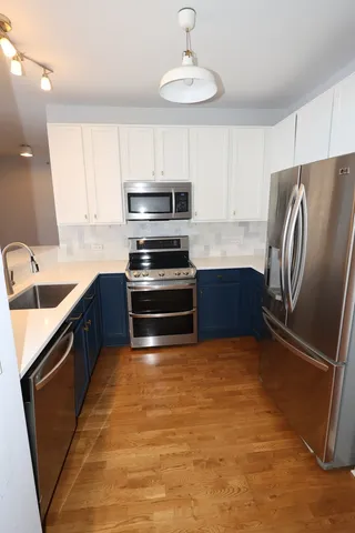 a kitchen with stainless steel appliances a refrigerator a sink a stove a microwave and island