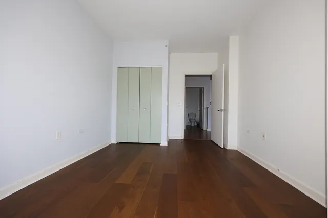an empty room with wooden floor and closet