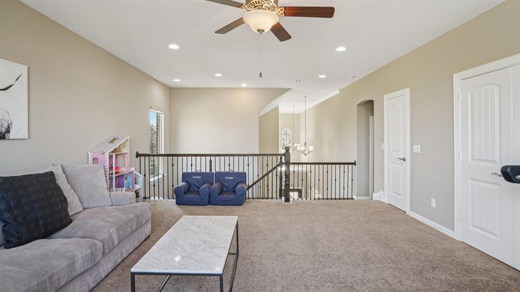 11192 Progreso Street Frisco, TX 75035 - Photo 25 of 30 a living room with furniture and a chandelier