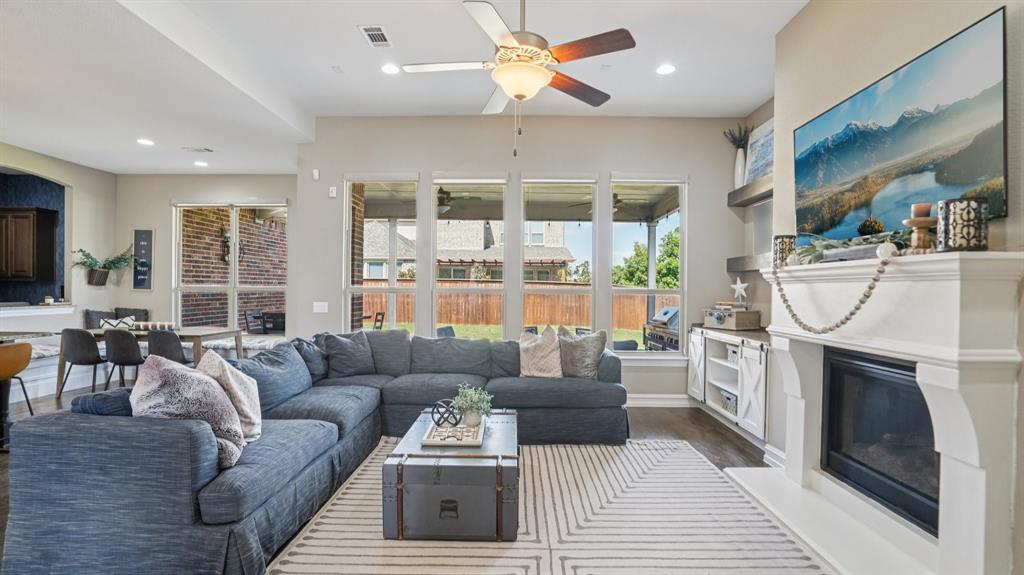 11192 Progreso Street Frisco, TX 75035 - Photo 5 of 30 a living room with furniture a fireplace and a flat screen tv