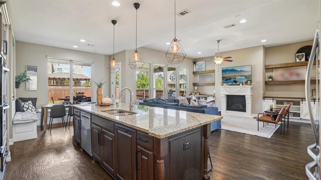 11192 Progreso Street Frisco, TX 75035 - Photo 7 of 30 a kitchen with stainless steel appliances granite countertop a stove and chairs