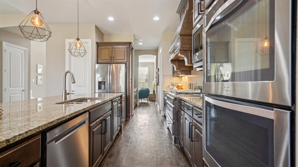 11192 Progreso Street Frisco, TX 75035 - Photo 10 of 30 a kitchen with stainless steel appliances granite countertop a sink and stove